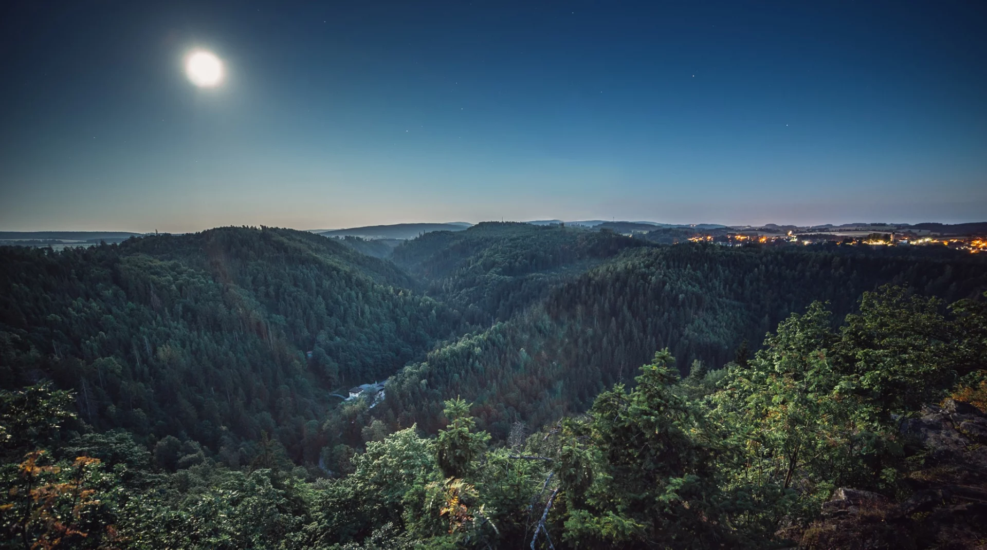 Blick über ein bewaldetes Tal im Hofer Land am Abend
