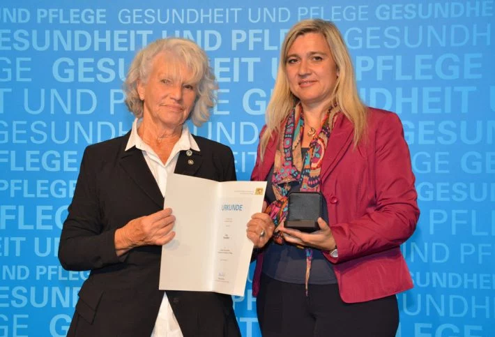 Erika Mohr mit Staatsministerin Melanie Huml MdL, bei der Verleihung der Bayerischen Staatsmedaille für Verdienste um Gesundheit und Pflege Fotoquelle: StMGP