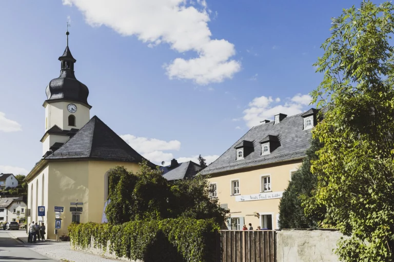 Dorfkirche mit Zwiebelturm und gelbes Gebäude mit Zwerchgiebeln in Joditz
