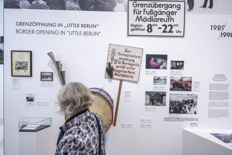 Frau betrachtet Ausstellungstafel zur Grenzöffnung 1989 im Museum Mödlareuth