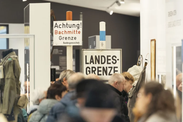 Besuchergruppe vor historischen Grenzschildern „Landesgrenze“ in der Museumsausstellung