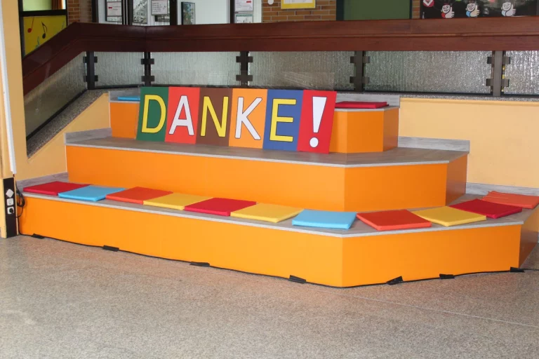 Dekorierte Treppe mit bunten Sitzkissen und Schriftzug „Danke!“ im Eingangsbereich der Schule