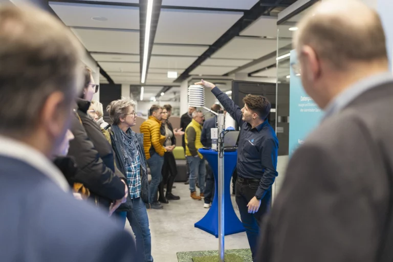 Besuchergruppe beobachtet Vorführung einer Wetterstation im InnovationsRAUM Hofer Land