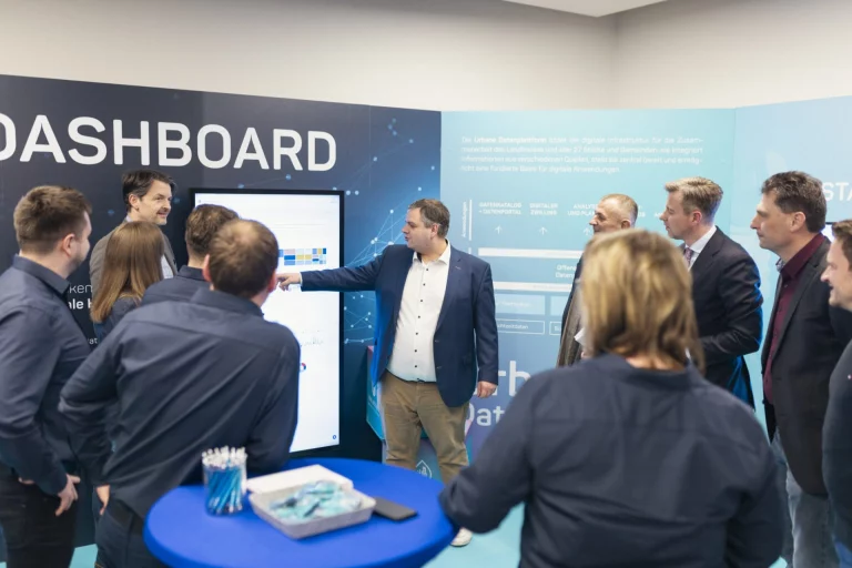 Mann erklärt Gruppe im InnovationsRAUM ein digitales Dashboard zur Datenplattform des Landkreises