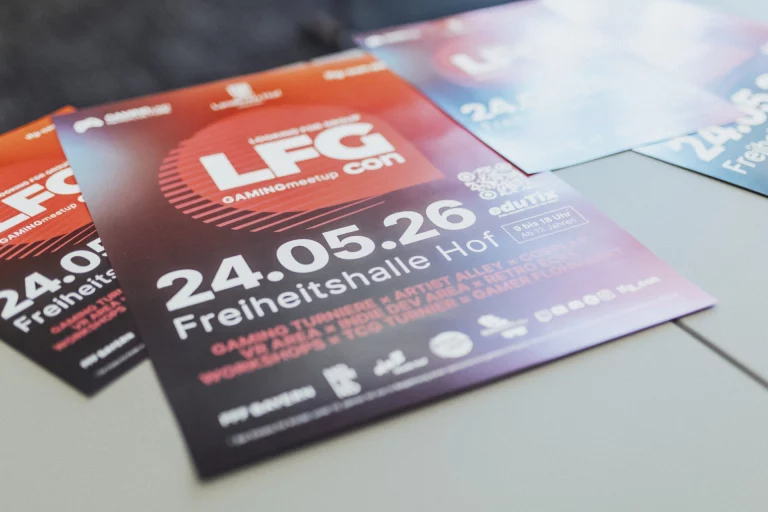 Gestapelte Flyer der LFG Con 2026 mit Datum und Veranstaltungsort Freiheitshalle Hof