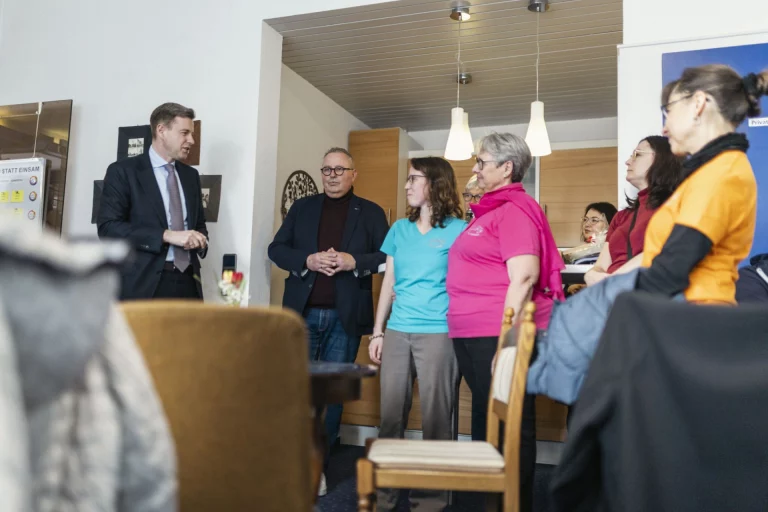 Landrat spricht mit Mitarbeiterinnen und Besucherinnen im Gemeinschaftsraum von Selbitz Kunterbunt
