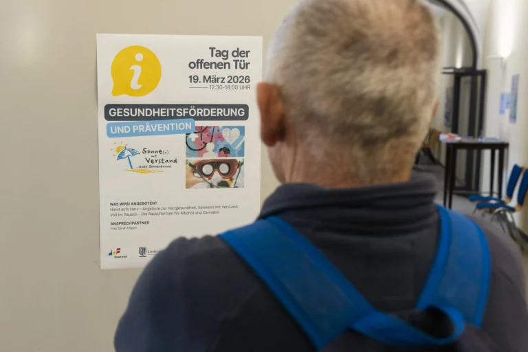 Rücken eines Mannes vor einem Aushang zum Tag der offenen Tür im Gesundheitsamt am 19. März 2026