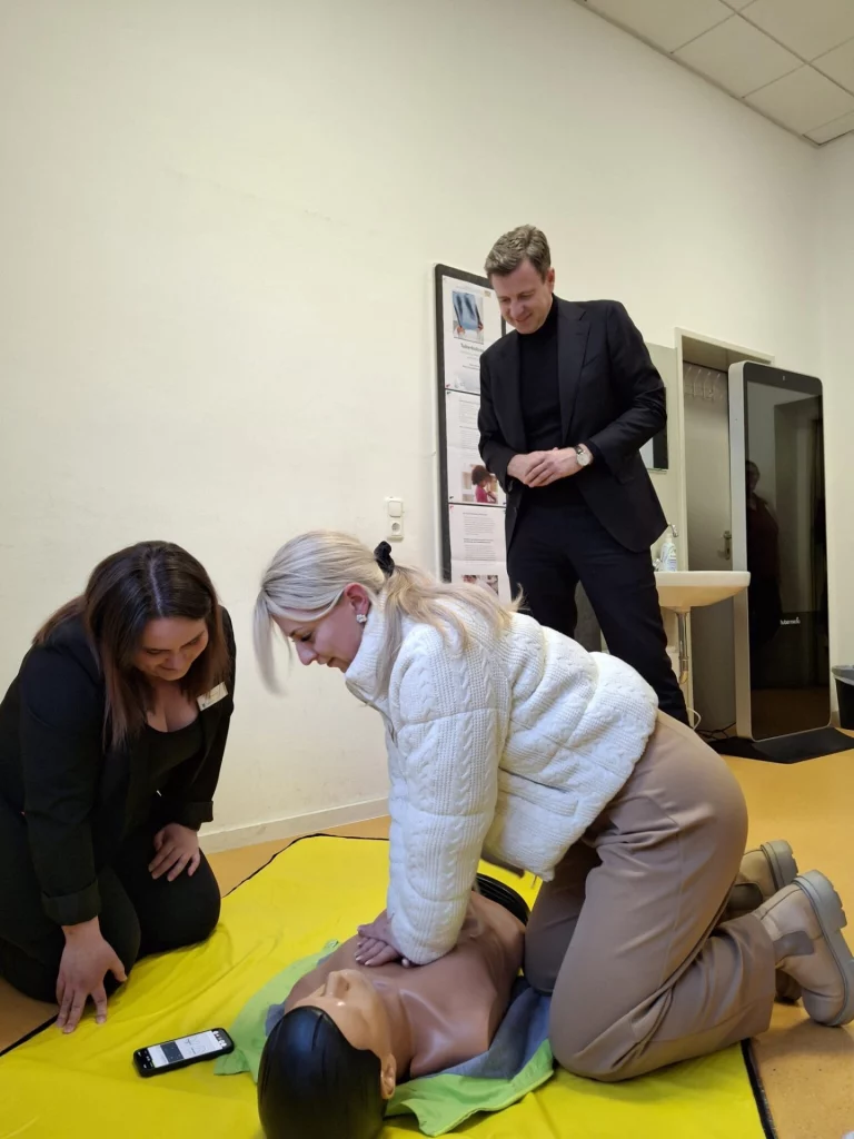 Erste-Hilfe-Übung mit Reanimationspuppe bei Besichtigung des Gesundheitsamtes