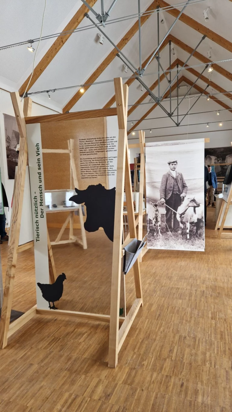 Museumsausstellung mit historischem Hofporträt und Infotafeln zu Tieren auf dem Bauernhof