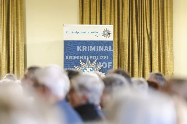 Rollup-Banner der Kriminalpolizeiinspektion Hof vor Publikum im Veranstaltungssaal