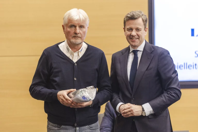 Zwei Männer bei der Übergabe einer Auszeichnung im Rahmen einer Ehrung