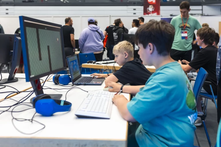 Jugendliche an PCs mit Headsets bei einem Gaming-Wettbewerb