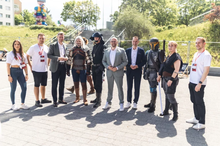 Landrat und Mitarbeiter stehen mit Cosplayern in Star-Wars- und Fantasy-Kostümen im Freien