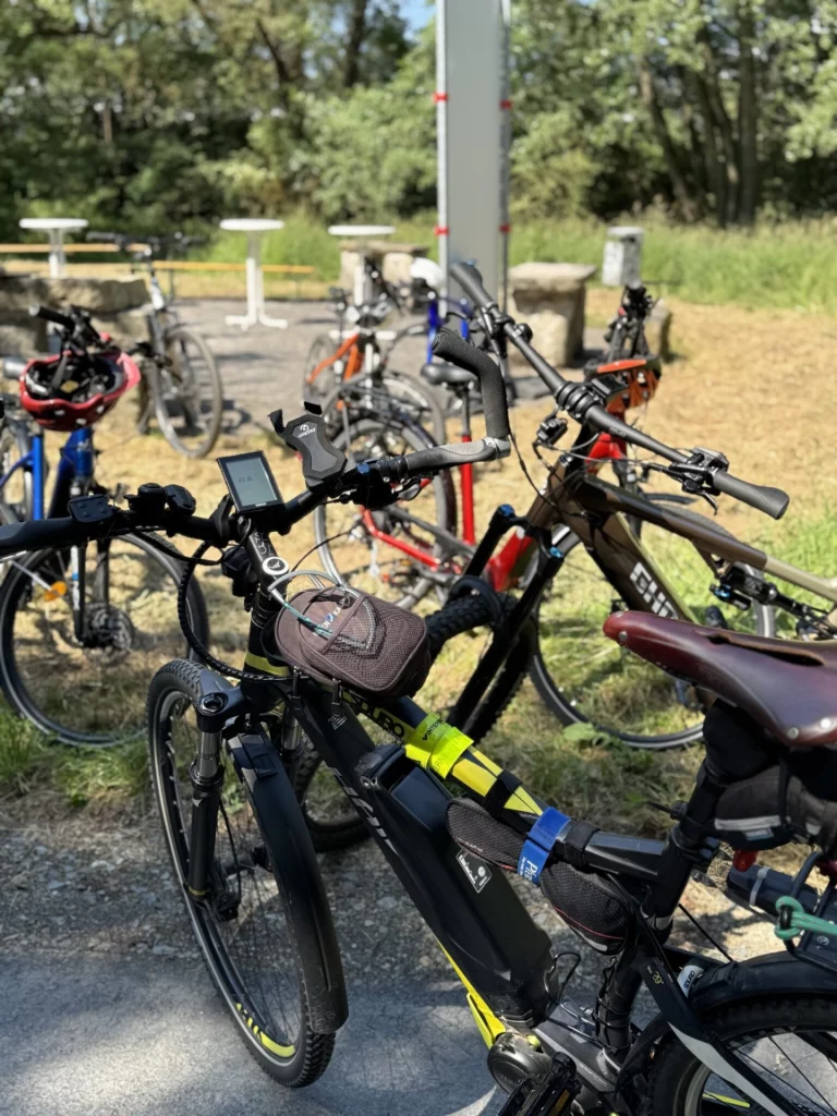 Mehrere Fahrräder stehen nebeneinander an einem Abstellplatz am Flüsseradweg