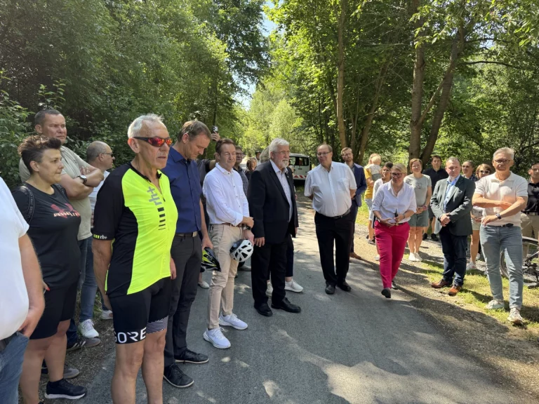 Gruppe von Personen bei der Einweihung eines Abschnitts des Flüsseradwegs auf einem Waldweg