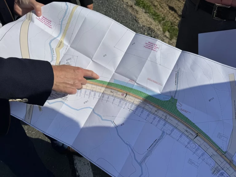 Hand zeigt auf Lageplan mit markierter Streckenführung für den geplanten Gehweg in Mödlareuth