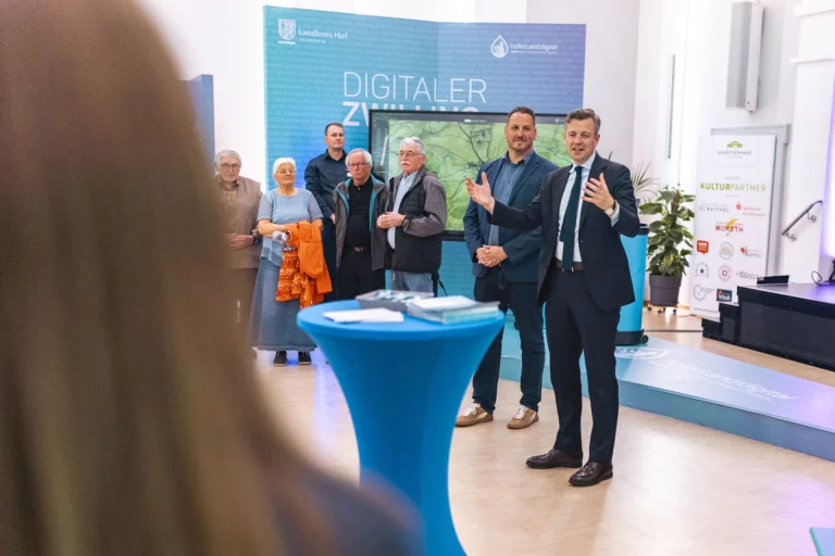 Landrat spricht bei Präsentation des Digitalen Zwillings vor Publikum und Bildschirm mit 3D-Karte