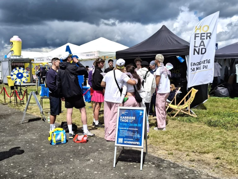 Infostand Hoferland mit Besuchern und Mitarbeitenden bei den MediMeisterschaften unter Zelten