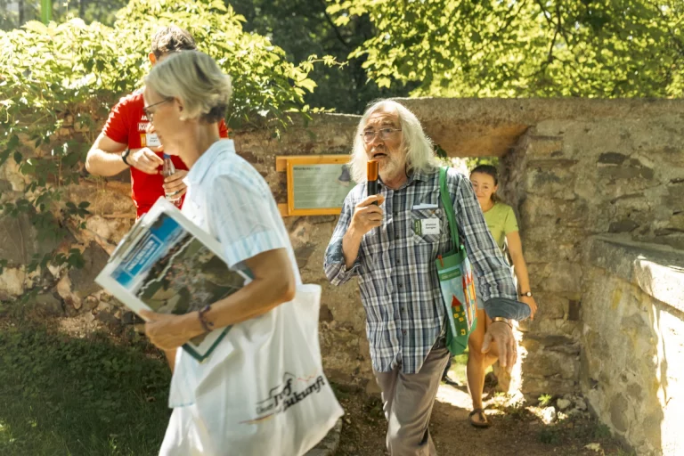 Besuchergruppe mit Informationsmaterial beim Rundgang durch die Ruine Hallerstein