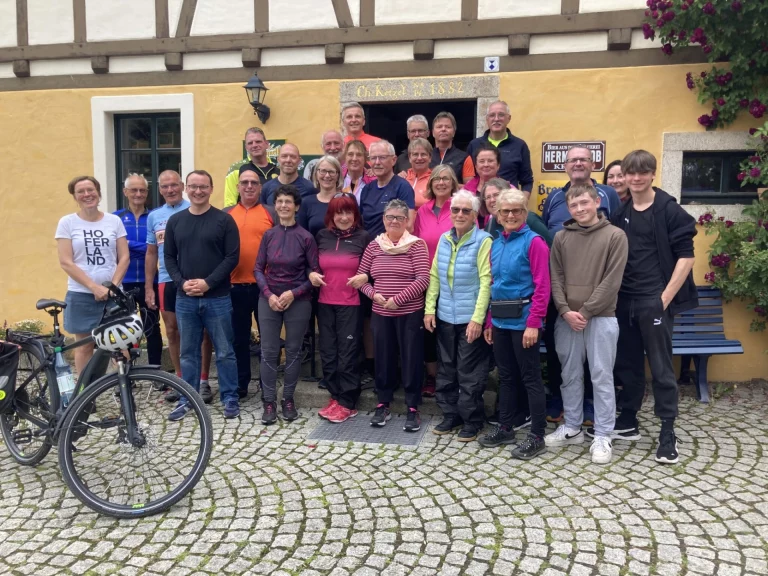 Gruppe von Radfahrenden posiert vor einem Fachwerkhaus bei der Eröffnungstour