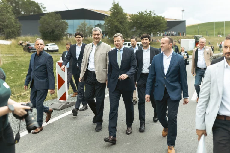 Gruppe von Männern in Anzügen geht gemeinsam über eine Straße bei der Veranstaltung in Mödlareuth