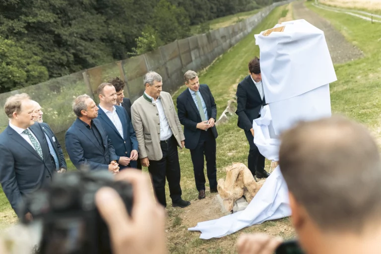 Gruppe von Personen bei der feierlichen Enthüllung eines verhüllten Gedenksteins am Grünen Band
