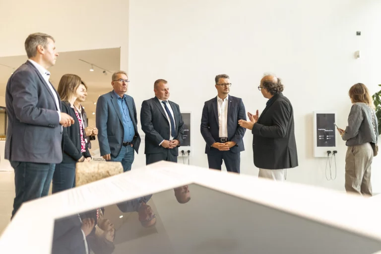 Gruppe von Personen bei einer Ausstellungsführung im Museum, im Hintergrund Informationstafeln