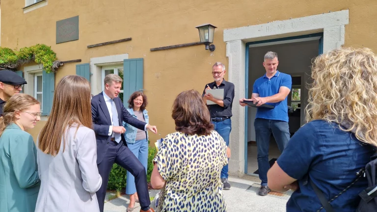 Landrat begrüßt Besuchergruppe im Innenhof des Jean-Paul-Museums