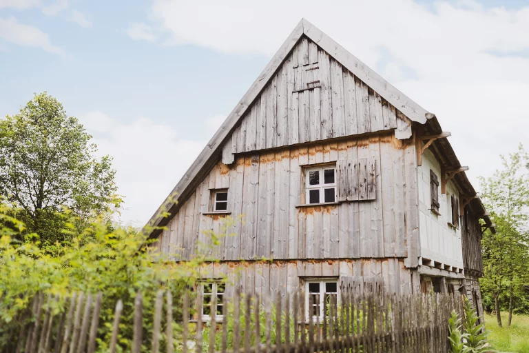 Historisches Fachwerkhaus mit Holzverschalung des Bauernhofmuseums hinter Staketenzaun